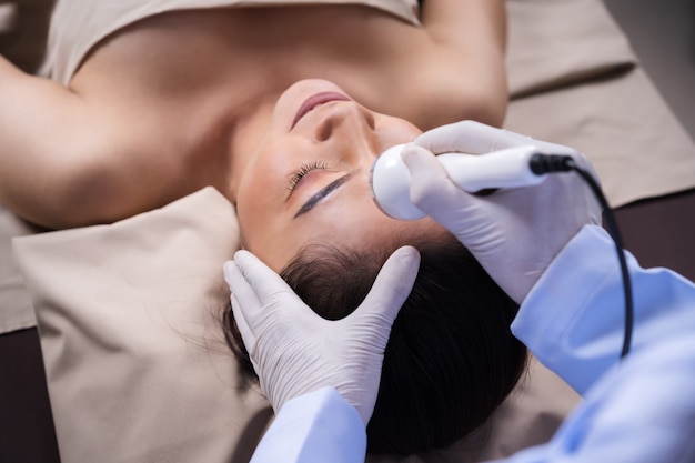 Woman receiving ultrasound facial beauty treatment skin care