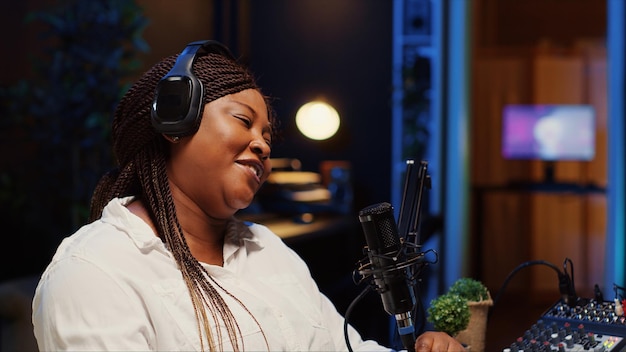 Photo woman recording podcast adjusting mic to ensure optimum sound quality