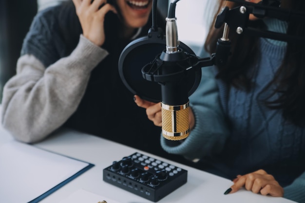 Woman recording a podcast on her laptop computer with headphones and a microscope Female podcaster making audio podcast from her home studio