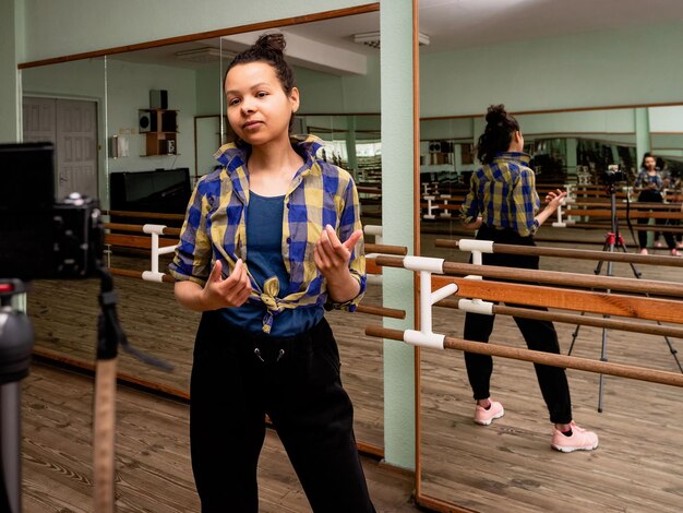 Foto donna registra una lezione video nella sala di coreografia bella giovane donna vlogger parla alla telecamera