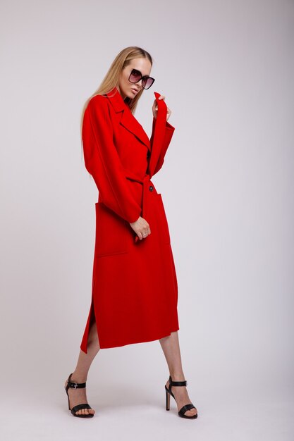 Woman in red autumn coat stylish sunglasses posing on white background Studio Shot Slim figure