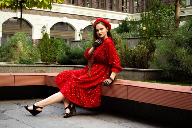 A woman in a red beret sits on a bench