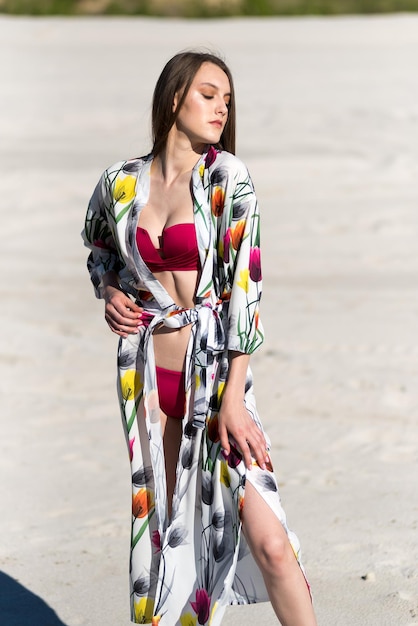 A woman in a red bikini and a flowered scarf