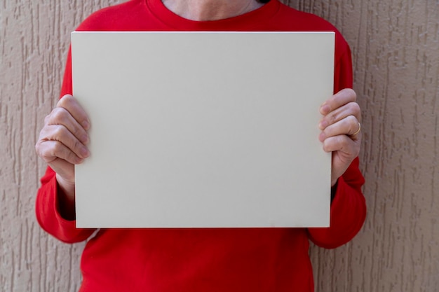 Woman in red blouse holding white sign