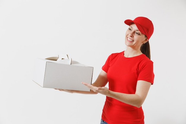 Woman in red cap, t-shirt giving food order cake box isolated on white background. Female courier holding dessert in unmarked cardboard box. Delivery service concept. Receiving package. Copy space.