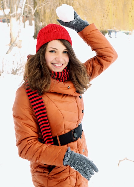 Woman in a red cap throwing snowball