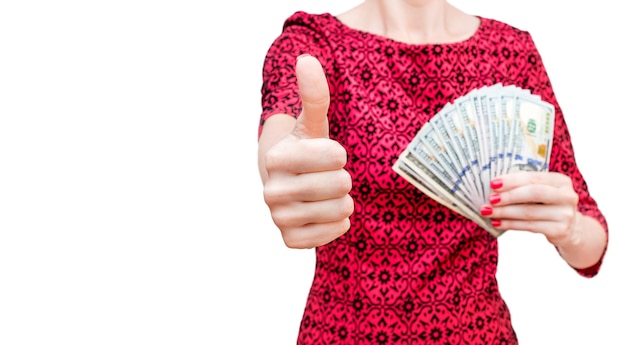 Woman in red dress holding money and showing thumbs up gesture Isolated on white