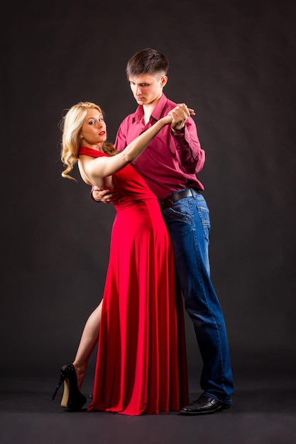 Woman in a red dress and man in a costume are posing