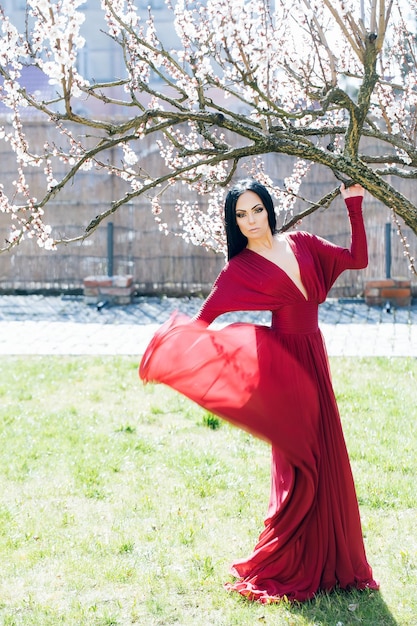 Woman in red dress near blossom