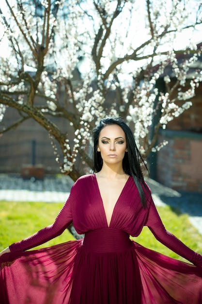 Woman in red dress near blossom