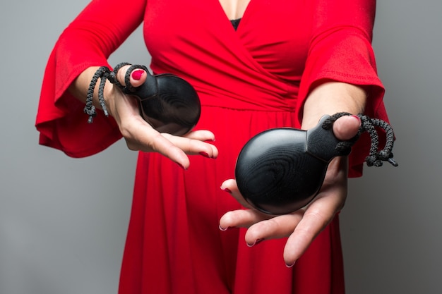 Woman in red dress playing Sevillian flamenco castanets