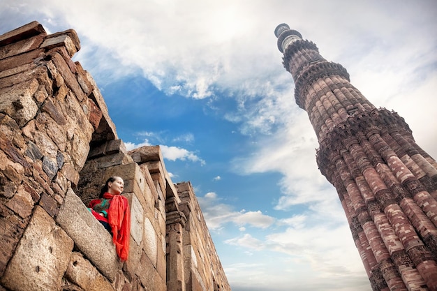 Qutub Minar 단지에서 빨간 드레스를 입은 여성