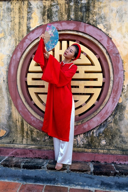 Photo woman in red dress raising her hand fan photo