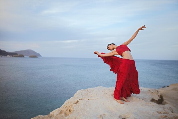 Photo woman in red dress on rock formation