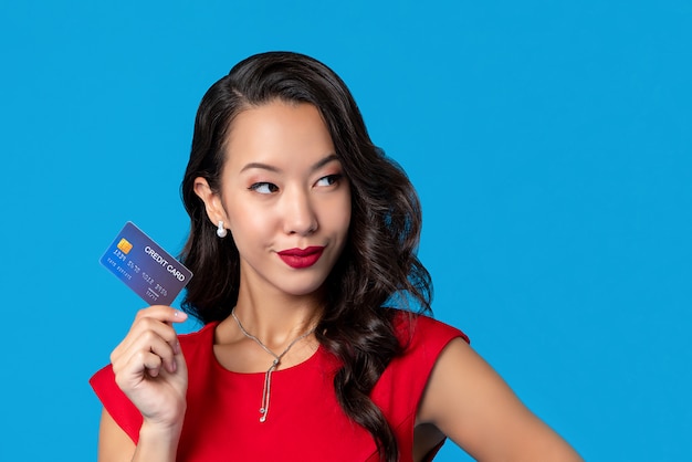 Woman in red dress showing credit card in hand