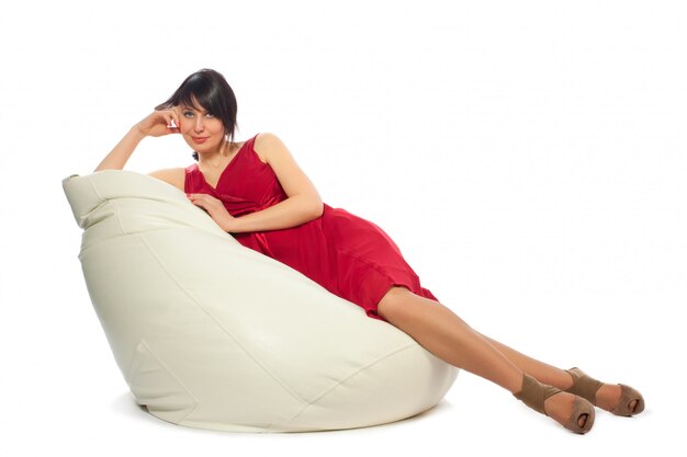 Woman in red dress sitting on armchair