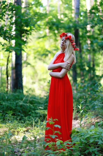 Woman in a red dress wearing a wreath of poppy on head