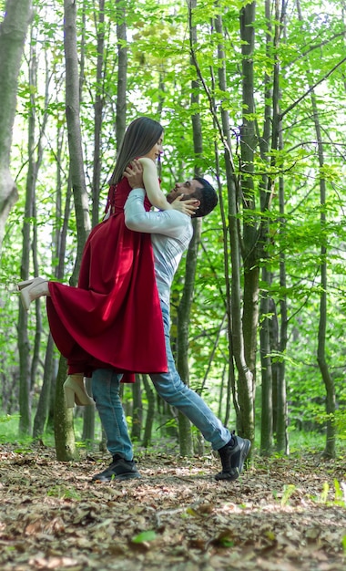 woman in red dress with boyfriend in the park young couple in the park