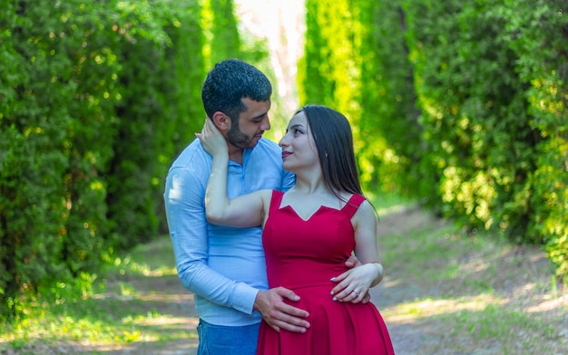 woman in red dress with boyfriend in the park young couple in the park