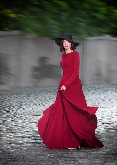Foto donna in abito da sera rosso in posa per strada