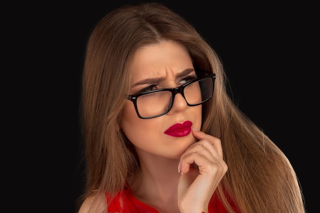 Woman in red in glasses is posing