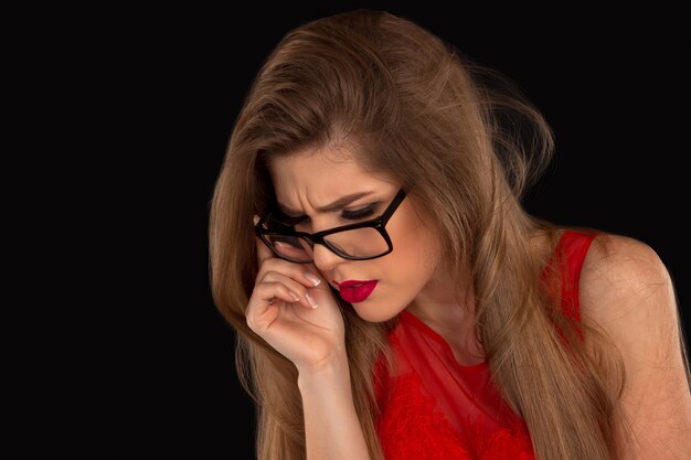 Woman in red in glasses is posing