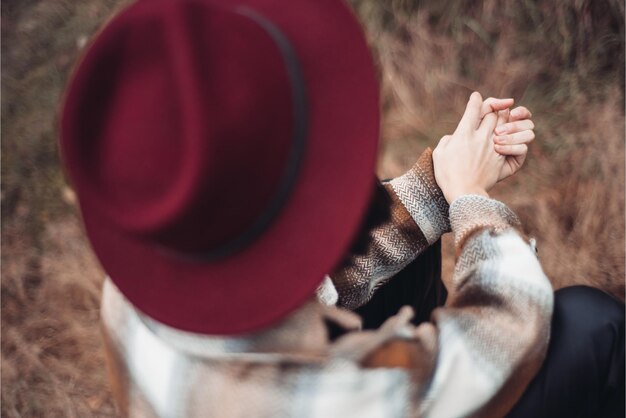 A woman in a red hat holds hands with the word love on the front.