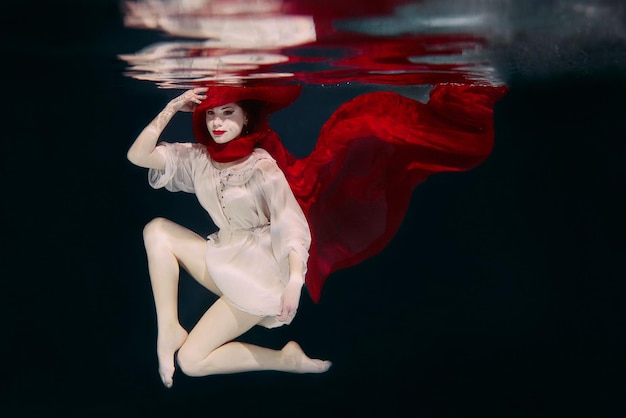 Woman in red hat and red scarf underwater