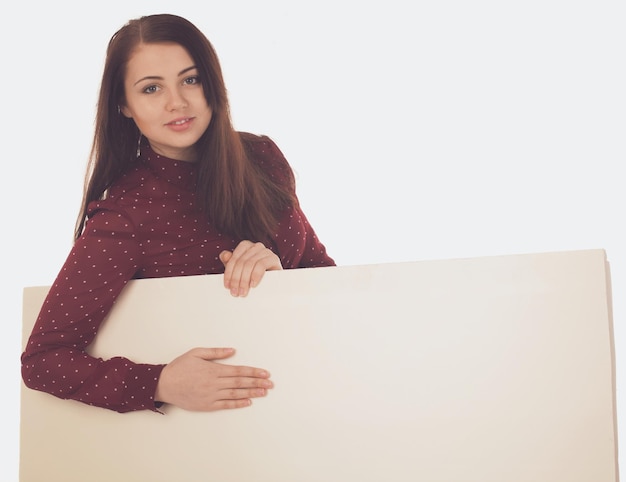 Woman in red is holding a canvas against of white background