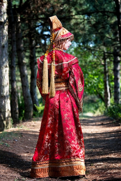 Photo woman in red kimono with a small parcel in summer day