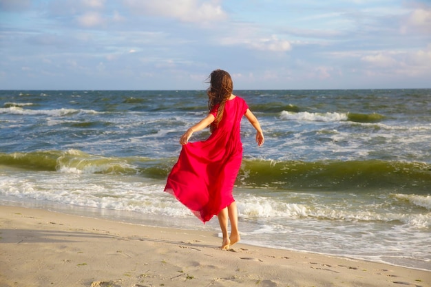 Woman in red on the sea coast