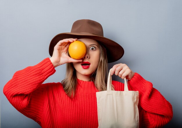 Woman in red sweater with orange and bag 