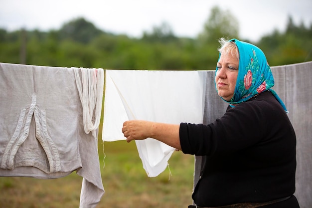 A woman in a refugee camp hangs clothes to dry outside