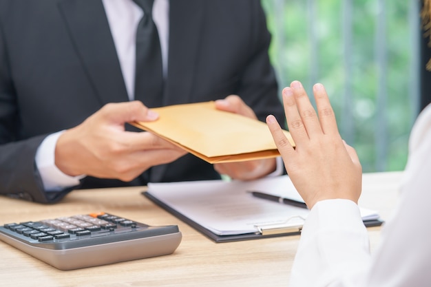 Photo woman rejecting money in envelope offered by a businessman