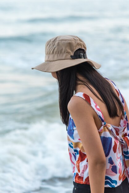 女性は概念旅行で海のビーチでリラックスします。