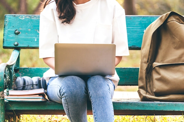 Woman relax with laptop computer sitting on grass in park