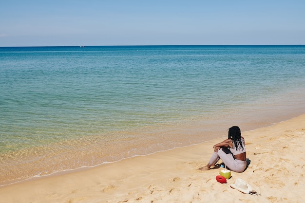 Foto donna che si distende sulla spiaggia