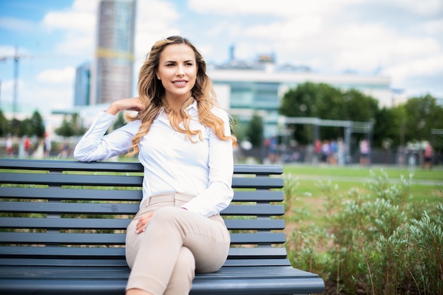 Woman relaxing on a bench in a city park