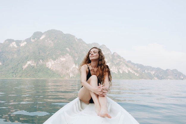 Женщина, отдыхая на каноэ у озера