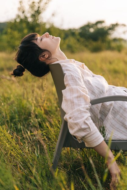 草原の椅子でくつろぐ女性