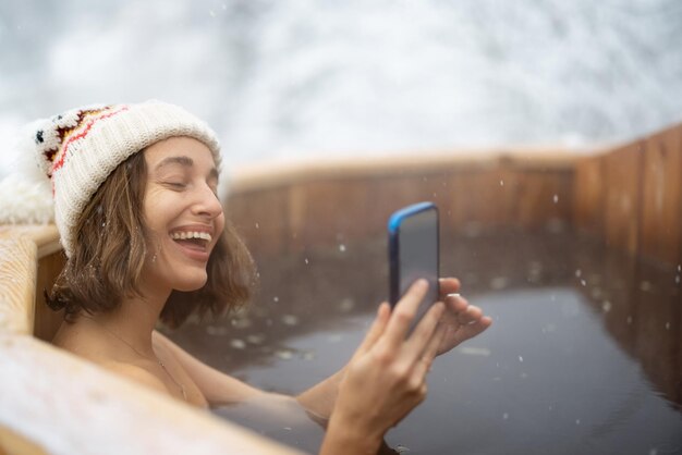 Woman relaxing in hot bath at snowy mountains