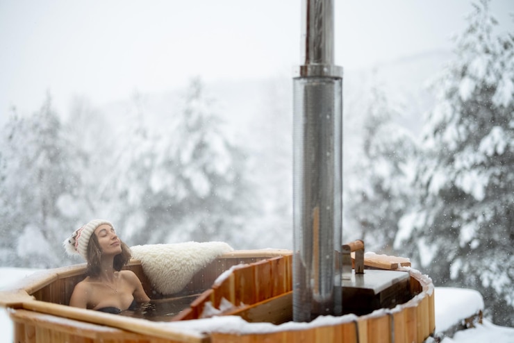 Photo woman relaxing in hot bath at snowy mountains