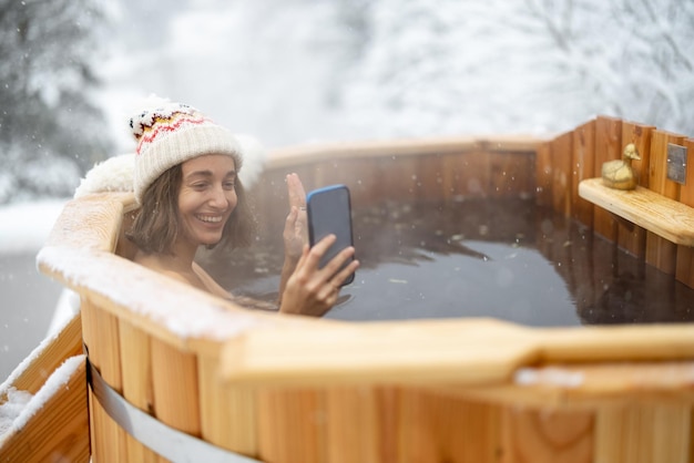 Woman relaxing in hot bath at snowy mountains