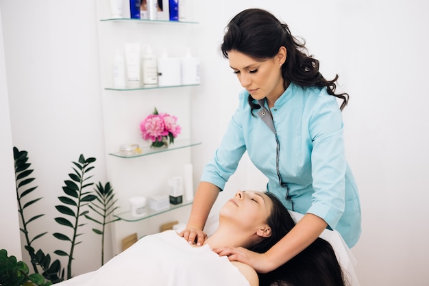 woman relaxing during massage lying on massage table young woman having massage by a female masseur