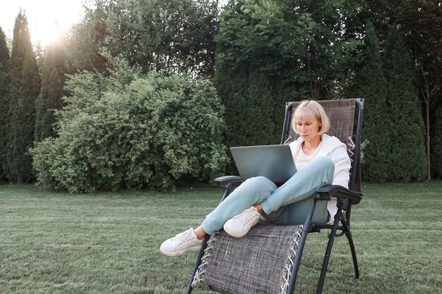 Woman Relaxing In Nature And Using Technology