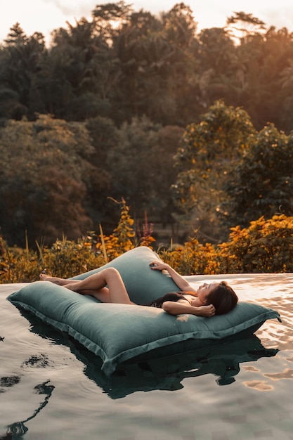 Photo woman relaxing on pool raft in swimming pool