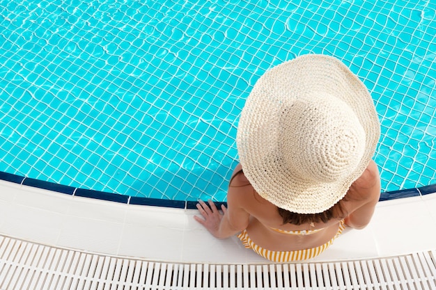 Woman relaxing in swimming pool on summer vacation Hot sunny holiday concept With copy space