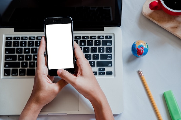 Woman relaxing while using smartphone blank screen for graphics display montage.