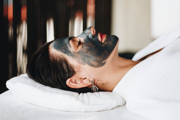 Woman relaxing with a facial mask at the spa