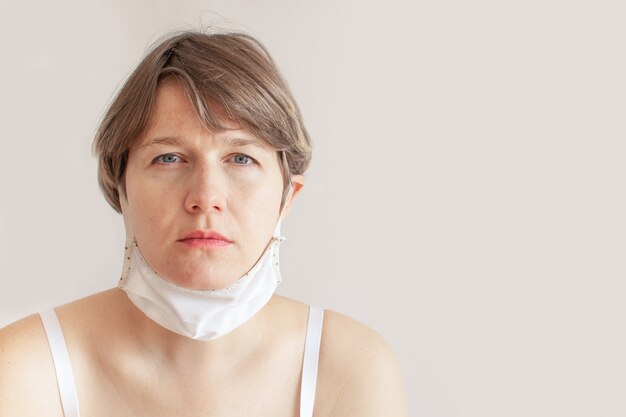 Woman removes cotton linen medical mask coronavirus epidemic.